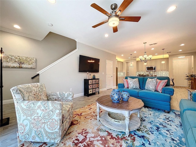 living room featuring light hardwood / wood-style floors, crown molding, and ceiling fan with notable chandelier