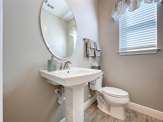 bathroom featuring toilet and wood-type flooring