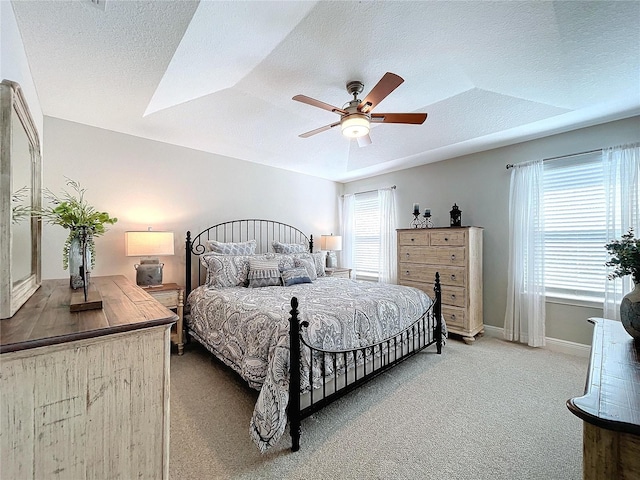 carpeted bedroom featuring a textured ceiling and ceiling fan