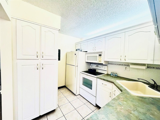 kitchen with sink, white cabinets, white appliances, light tile patterned floors, and backsplash