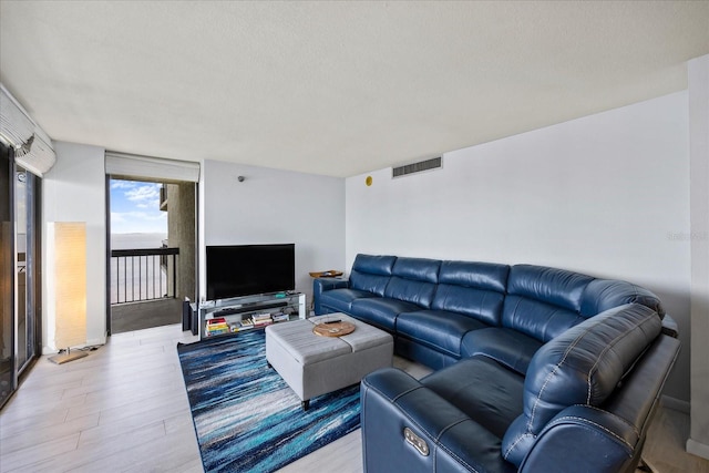 living room with light hardwood / wood-style floors and a textured ceiling