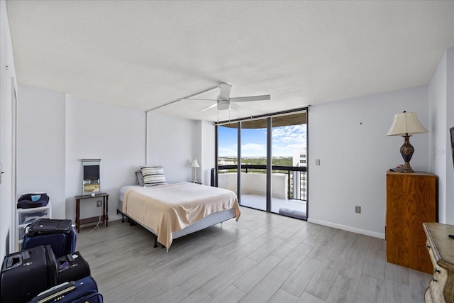 bedroom featuring light wood-type flooring, a textured ceiling, access to exterior, ceiling fan, and expansive windows