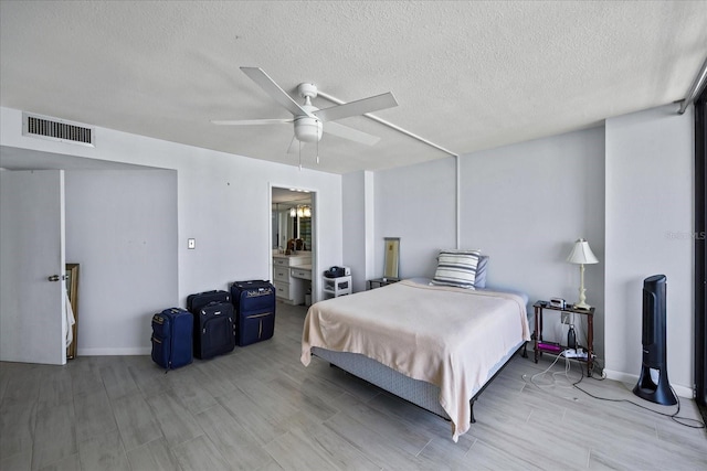 bedroom with a textured ceiling, light hardwood / wood-style floors, and ceiling fan