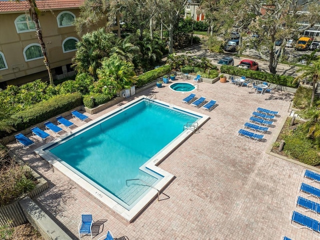 view of pool with a hot tub and a patio area