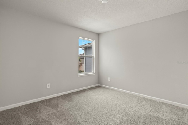 carpeted spare room with a textured ceiling