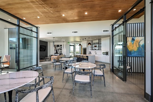 dining space with french doors, concrete floors, and wooden ceiling