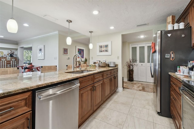 kitchen featuring sink, hanging light fixtures, stainless steel appliances, light stone counters, and ornamental molding