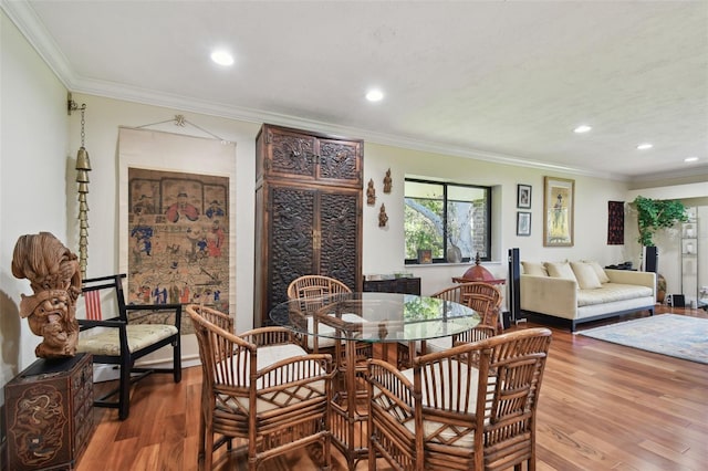 dining space with ornamental molding and hardwood / wood-style flooring