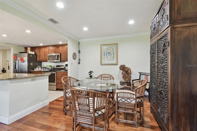 dining area featuring ornamental molding and wood-type flooring