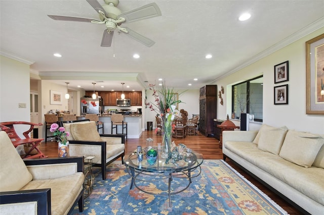 living room with crown molding, wood-type flooring, and ceiling fan