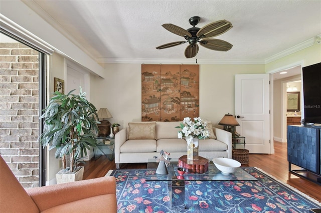 living room with crown molding, wood-type flooring, a textured ceiling, and ceiling fan