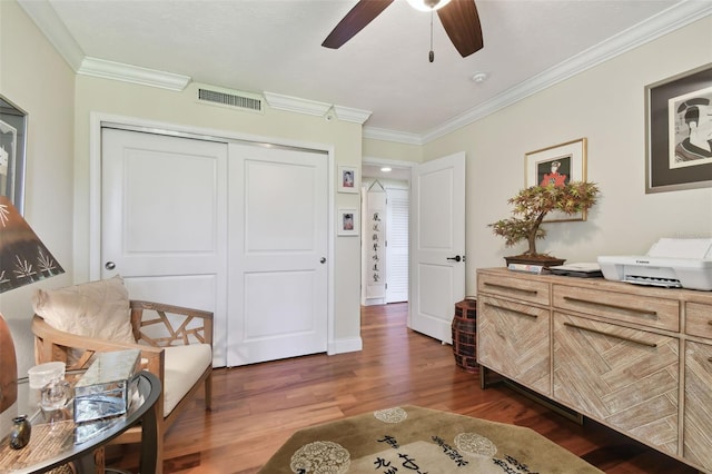 living area with crown molding, dark hardwood / wood-style flooring, and ceiling fan