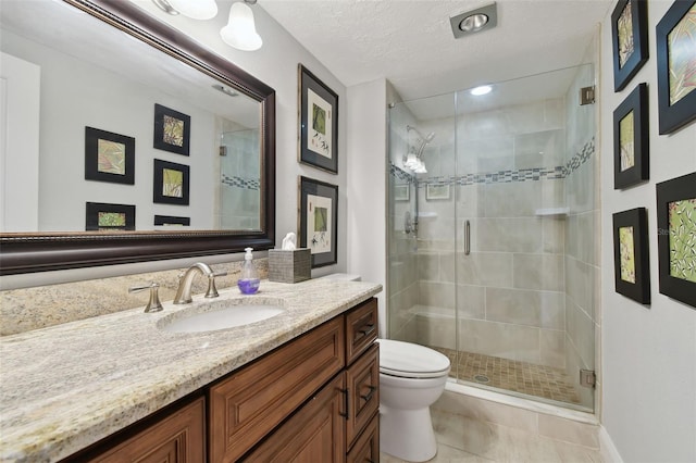 bathroom with a textured ceiling, toilet, vanity, an enclosed shower, and tile patterned floors