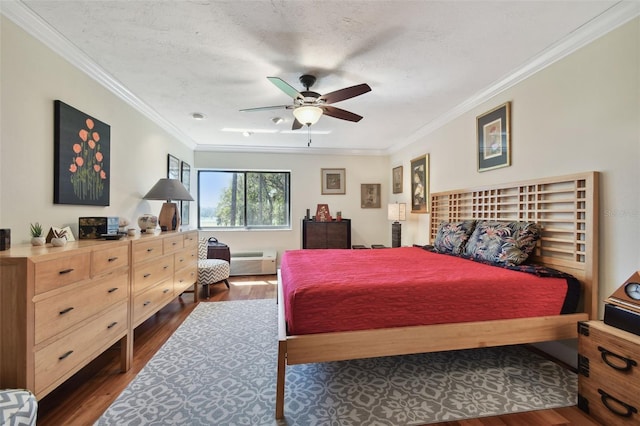 bedroom with a textured ceiling, ceiling fan, a wall unit AC, ornamental molding, and dark hardwood / wood-style floors