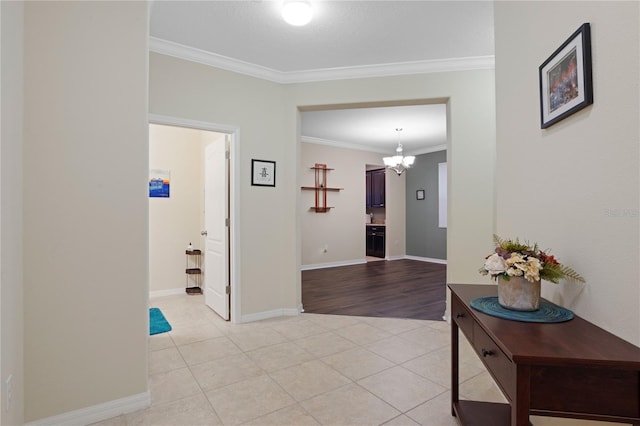 hall featuring ornamental molding, a chandelier, and light tile patterned floors