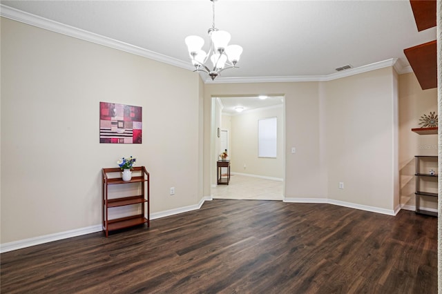 empty room featuring crown molding, an inviting chandelier, and dark hardwood / wood-style floors