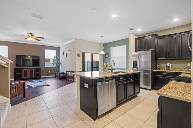 kitchen featuring a kitchen island with sink, sink, decorative light fixtures, light wood-type flooring, and appliances with stainless steel finishes