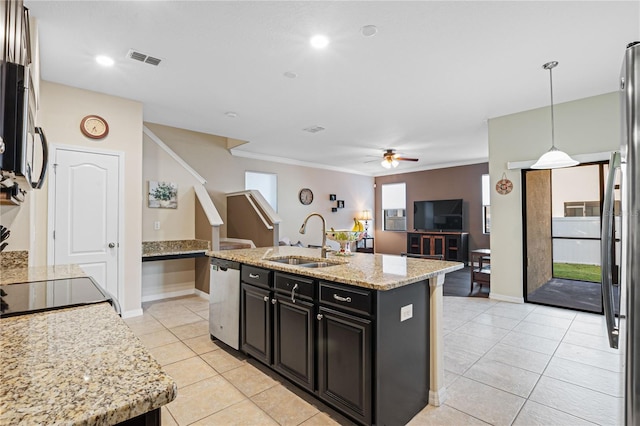 kitchen with appliances with stainless steel finishes, a kitchen island with sink, light stone countertops, sink, and decorative light fixtures