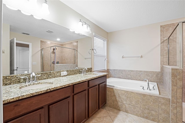 bathroom featuring vanity, plus walk in shower, a textured ceiling, and tile patterned flooring