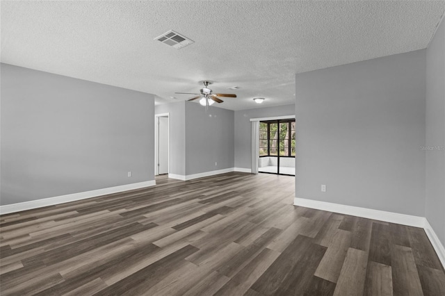 empty room featuring a textured ceiling, dark wood-type flooring, and ceiling fan