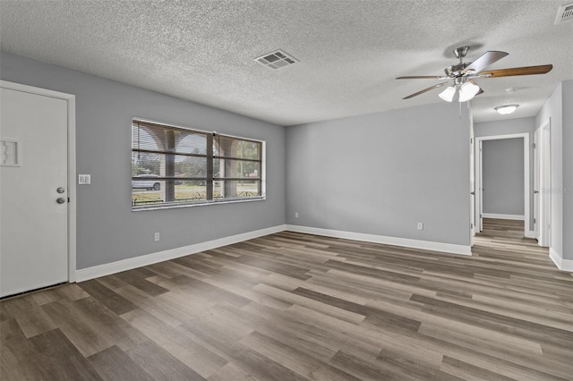 spare room with hardwood / wood-style floors, a textured ceiling, and ceiling fan