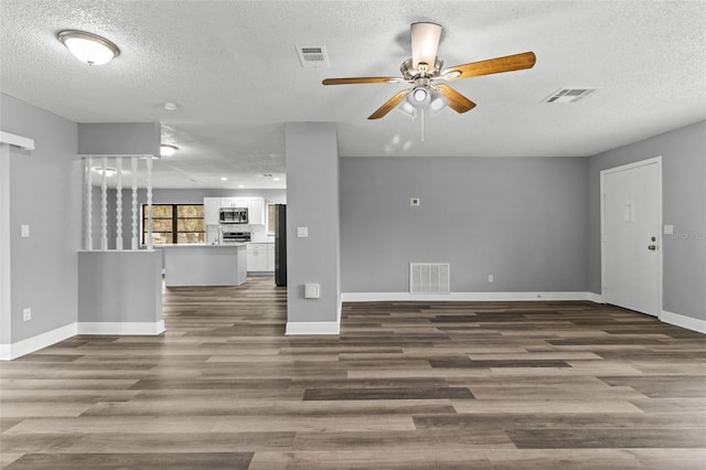 unfurnished living room featuring a textured ceiling, wood-type flooring, and ceiling fan