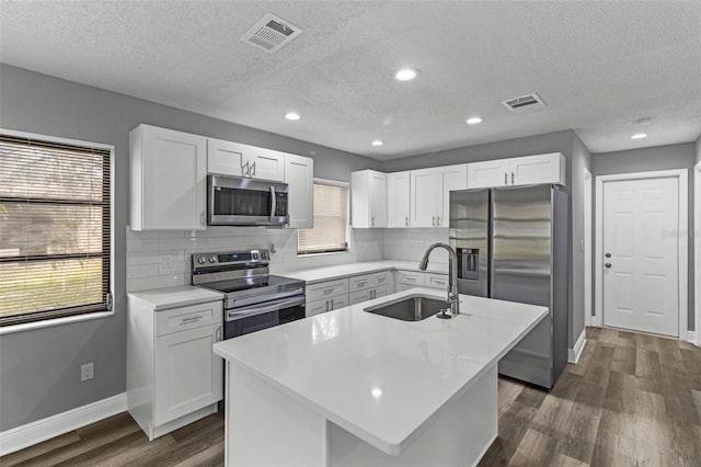 kitchen featuring white cabinetry, a kitchen island with sink, stainless steel appliances, and sink