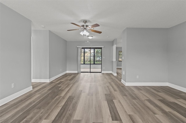 unfurnished living room with ceiling fan, a textured ceiling, and light hardwood / wood-style flooring