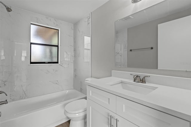 full bathroom with tiled shower / bath, vanity, and toilet