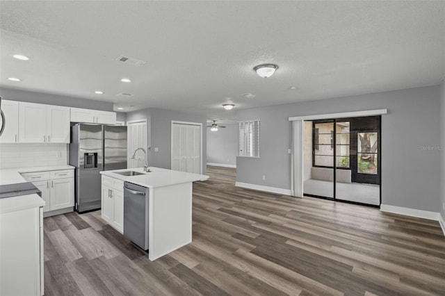 kitchen featuring white cabinets, dark hardwood / wood-style flooring, appliances with stainless steel finishes, a kitchen island with sink, and sink