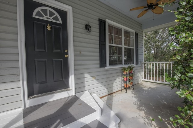 view of exterior entry featuring ceiling fan and a porch