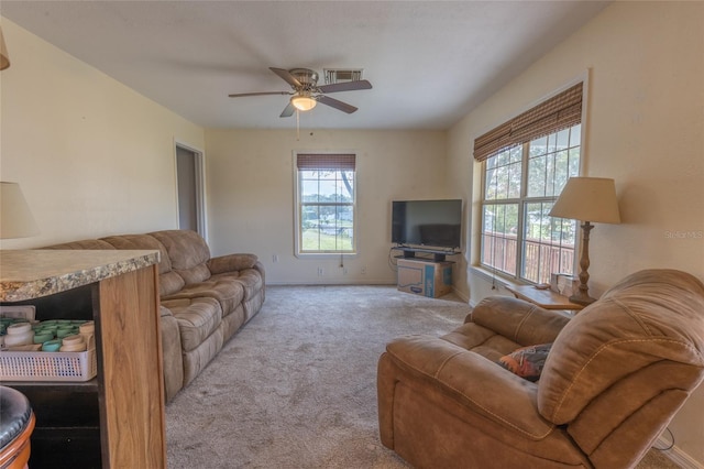 carpeted living room with ceiling fan