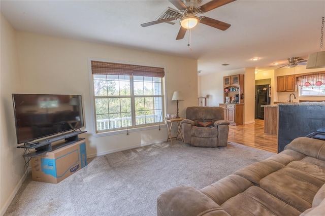 carpeted living room with sink and ceiling fan