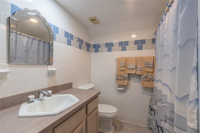 bathroom featuring tile patterned floors, toilet, curtained shower, tile walls, and vanity