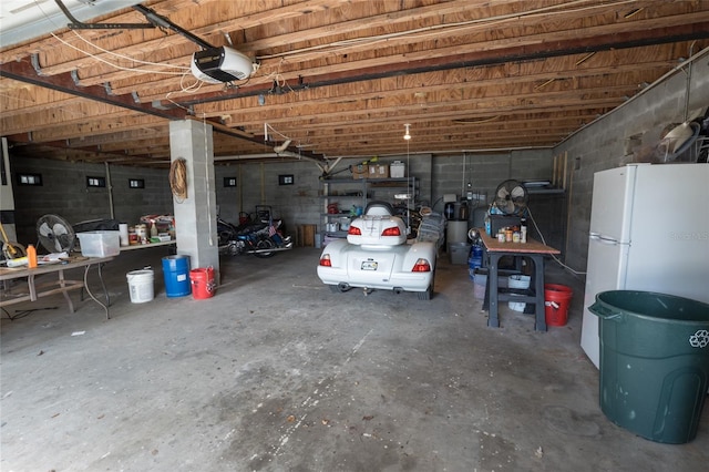 garage featuring white fridge and a garage door opener