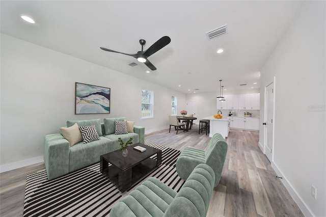 living room with ceiling fan and light hardwood / wood-style floors