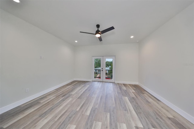 empty room featuring ceiling fan, french doors, and light hardwood / wood-style floors