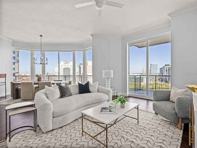 living area featuring a city view, crown molding, light wood-style floors, a textured ceiling, and baseboards