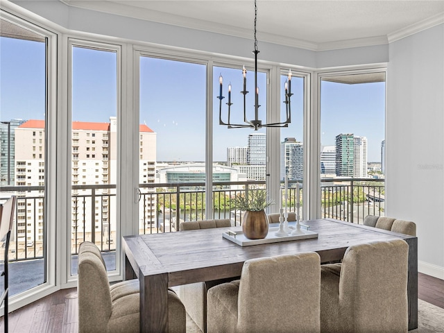 dining room featuring crown molding, a chandelier, wood finished floors, and a city view