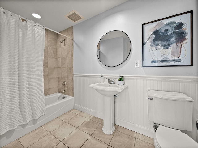 bathroom with toilet, tile patterned floors, and shower / bath combo with shower curtain