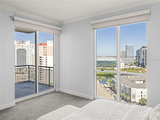 carpeted bedroom with a water view, crown molding, and multiple windows