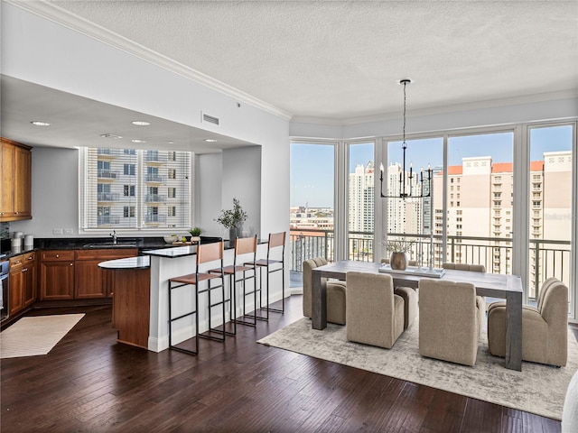 dining area with a view of city, dark wood-style flooring, visible vents, and an inviting chandelier