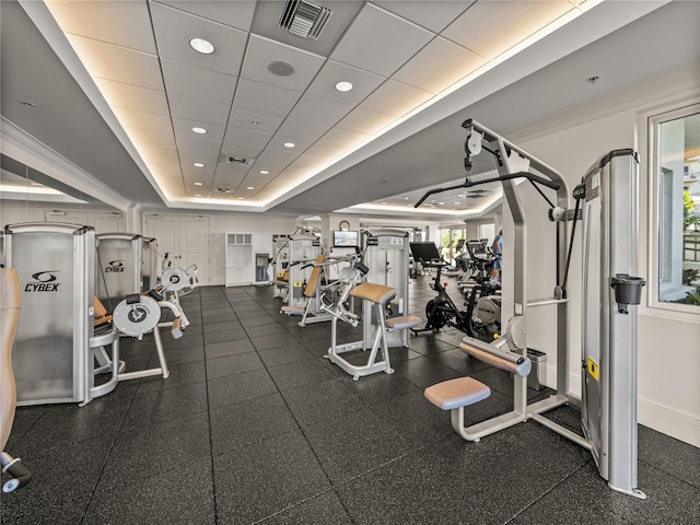 workout area featuring a paneled ceiling, a raised ceiling, visible vents, recessed lighting, and baseboards