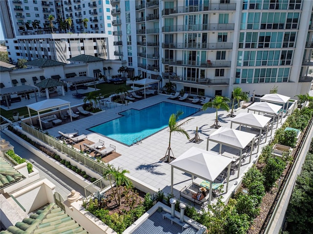 community pool with a gazebo and a patio