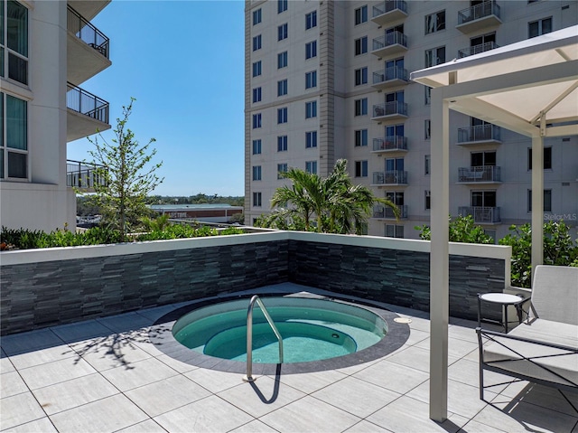 view of swimming pool featuring a patio area and a hot tub