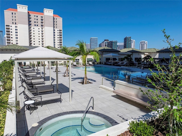 view of pool featuring a hot tub, a patio area, and a gazebo