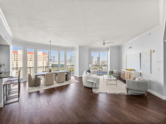 living room featuring a city view, crown molding, baseboards, and wood finished floors