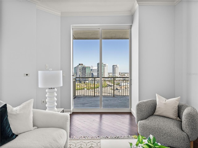 living area featuring a view of city, crown molding, baseboards, and wood finished floors