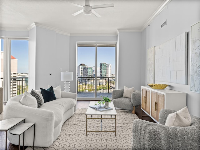 living room with crown molding, ceiling fan, visible vents, and a city view