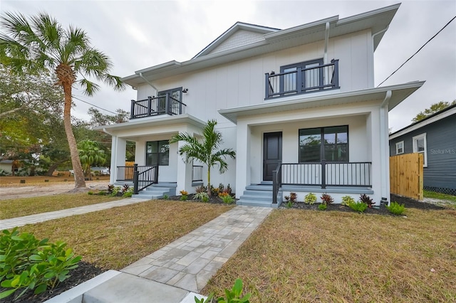 view of front of property with a porch, a balcony, and a front lawn